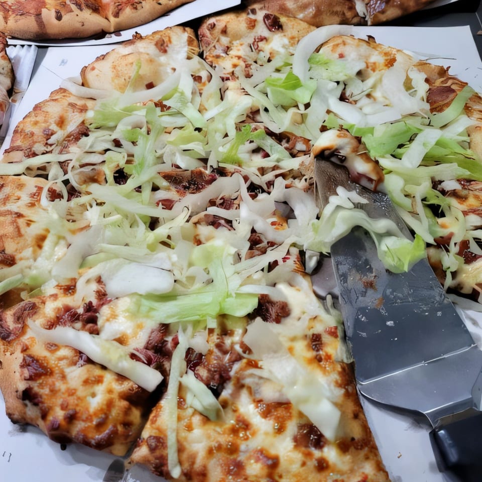A Pizzano's Buffet pizza with cheese, meat, shredded lettuce, and a spatula removing a slice.